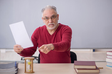 Old male teacher in time management concept