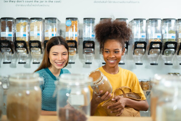 Mixed Race Woman Buying Cereals And Grains In Sustainable Plastic Free Grocery  and refill store with reusable bag.Environment-friendly, sustainable lifestyles.