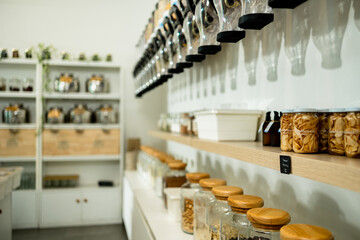 Eco-friendly zero waste shop interior. Dispensers for cereals, nuts and grains in sustainable plastic free grocery store. Shopping at small local businesses