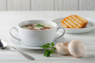 Mushroom cream soup on a white wooden board. side view