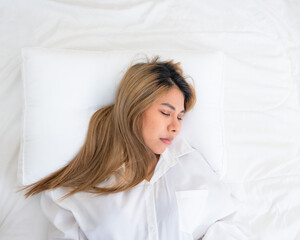 cute asian girl funny on bed with pillow