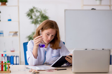 Young female chemist student working at the lab