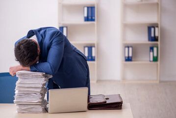 Young male employee and too much work in the office