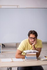 Young male student preparing for exams in the classroom