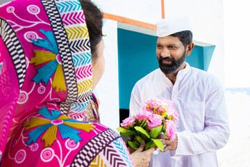 Indian man politician receive bouquet of flower by woman wearing sari. Concept of political leader...
