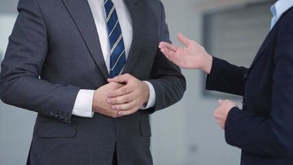 Close up hands of businessman and businesswoman wearing suit talking and discussed for work in meeting room at modern office