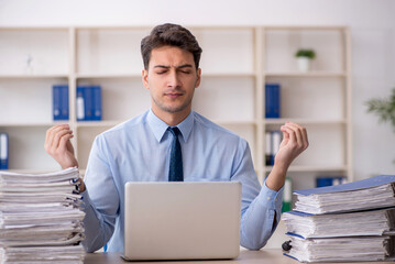 Young male employee and too much work in the office