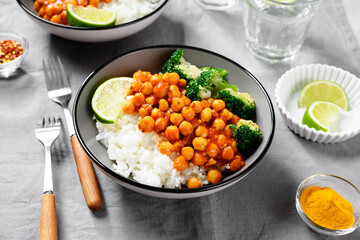 Chickpea curry with basmati rice and broccoli on gray background