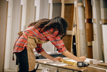 A Carpenter carefully measures, marks dimensions, and lays out reference lines on wood using scribe, divider, square, ruler, and caliper. The woodworking process need skills, experience, precision.