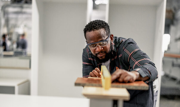 A Carpenter carefully measures, marks dimensions, and lays out reference lines on wood using scribe, divider, square, ruler, and caliper. The woodworking process need skills, experience, precision.