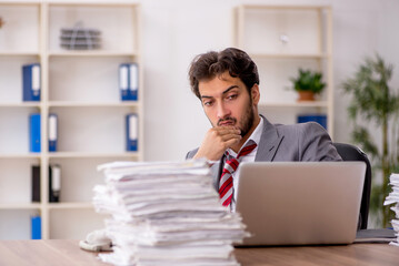 Young male employee unhappy with excessive work in the office