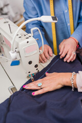Atelier process needle detail. Unrecognizable woman hand on a sewing machine doing handmade fabric