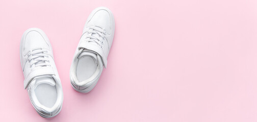 White sneakers on a pink background.