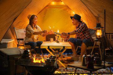 Asian couple enjoy in they tent in camping trip on night time