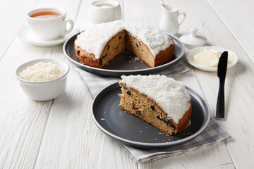 Boston bun baked from dough with mashed potatoes topped with a thick and fluffy icing closeup on the table. Horizontal