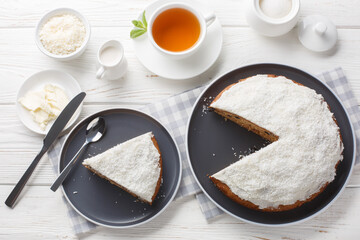 Boston bun with vanilla coconut frosting served with tea closeup on the table. Horizontal top view from above