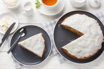 Boston bun baked from dough with mashed potatoes topped with a thick and fluffy icing closeup on the table. Horizontal top view from above