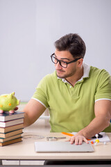 Young male student preparing for exams in the classroom