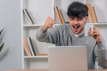 excited student at computer celebrating with joy