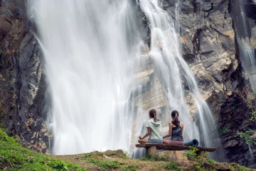 Foto op Plexiglas Asian traveller woman pose yoga in lotus pose with waterfall background © anekoho