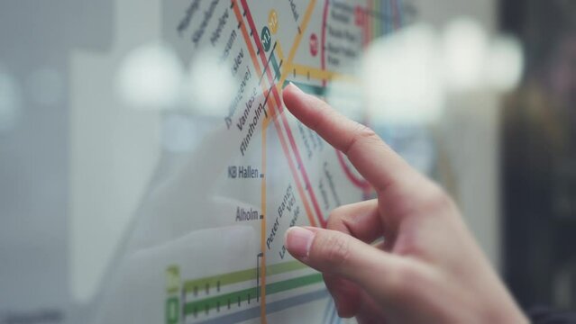 Finger of woman pointing on the Denmark railway map .Find the route of railway in Copenhagen main station