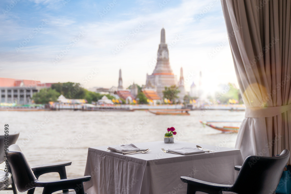 Wall mural Dinner table in restaurant with Wat arun pagoda and temple back ground