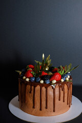 Chocolate cake in chocolate glaze with strawberries, blueberries and blackberries. Cooking and dessert recipes