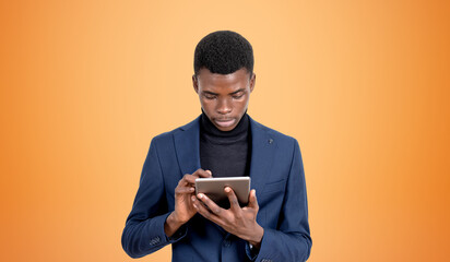 Black businessman typing in tablet in hands, copy space