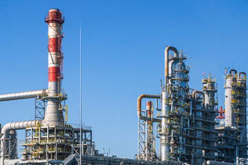 Primary processing of crude oil entering the refinery.  Equipment for the production of fuel components. Factory pipes at a chemical plant. Factory and blue sky. The distillation column at the factory