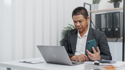 Using laptop pc, Elderly Old Senior Asian male businessman wearing formal suit ,confident professional bookkeeper doing bookkeeping, lawyer, stock market trader or broker.