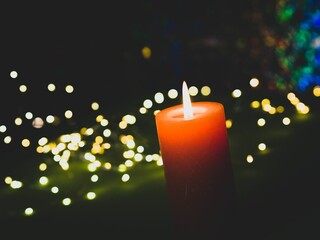 Closeup shot of a burning candle on a glowing bokeh background