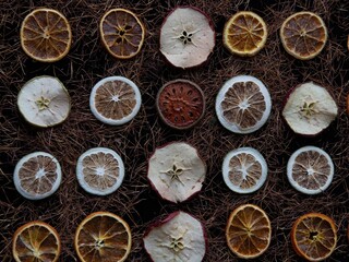 Top view of different dried citruses and apples in a pattern