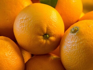 Obraz na płótnie Canvas Closeup shot of a pile of fresh oranges placed under the sunlight