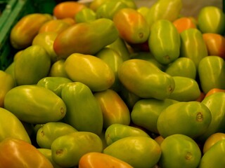 Closeup shot of a pile of yellow bell tomatoes found in the marketplace