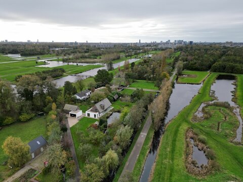 Fototapeta Aerial view over rural houses with trees and canals in Veenendaal, Utrecht Netherlands