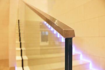 Laminated glass railing with stainless steel handrail gold color.