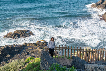 A young tourist at a viewpoint of a beautiful black sand beach. Benijo Beach, Tenerife