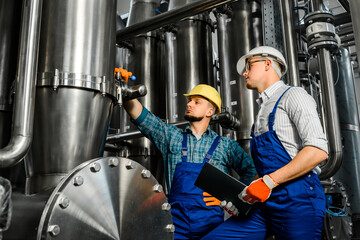 Two young engineers inspect an industrial plant for the treatment of contaminated water. Top view...