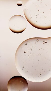 a drop of oil connects with another drop, golden background