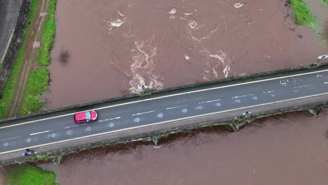Aerial shot of the cars driving on the Usk bridge over the river