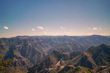 Aerial shot of Copper Canyon with rocky mountains and ravines under the blue sky