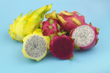 Assortment of dragon fruits on blue background close up.