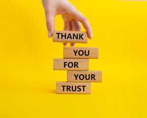 Thank you for your trust symbol. Wooden blocks with words Thank you for your trust. Beautiful yellow background. Businessman hand. Business and Thank you for your trust concept. Copy space