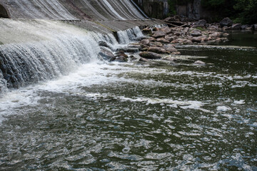 Picturesque textured waterfall on the river. There are big rocks along the river. Image of falling...