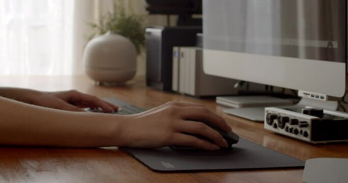 Hands of a video editor editing a project working from a home