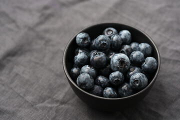 Freshly washed organic blueberries in a black bowl closeup