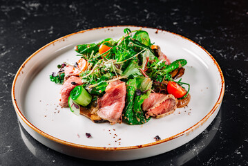 Roast beef salad with vegetables on plate