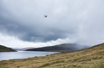 Plane landing in Faroe Islands, Vagar airport. Plane flying over amazing Sorvagsvatn Leitisvatn lake in the rain, Northern Europe, Scandinavia