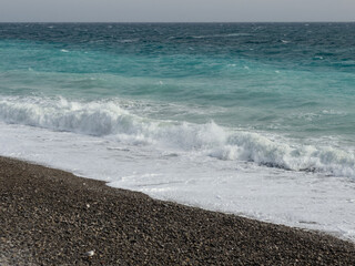 Pebble beach of Nice, France with azure waves of mediterranean sea