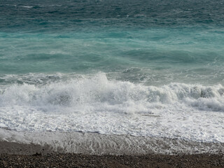 Pebble beach of Nice, France with azure waves of mediterranean sea